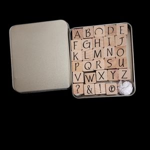 tin with the alphabet rubber stamps, plus four others, missing the T,